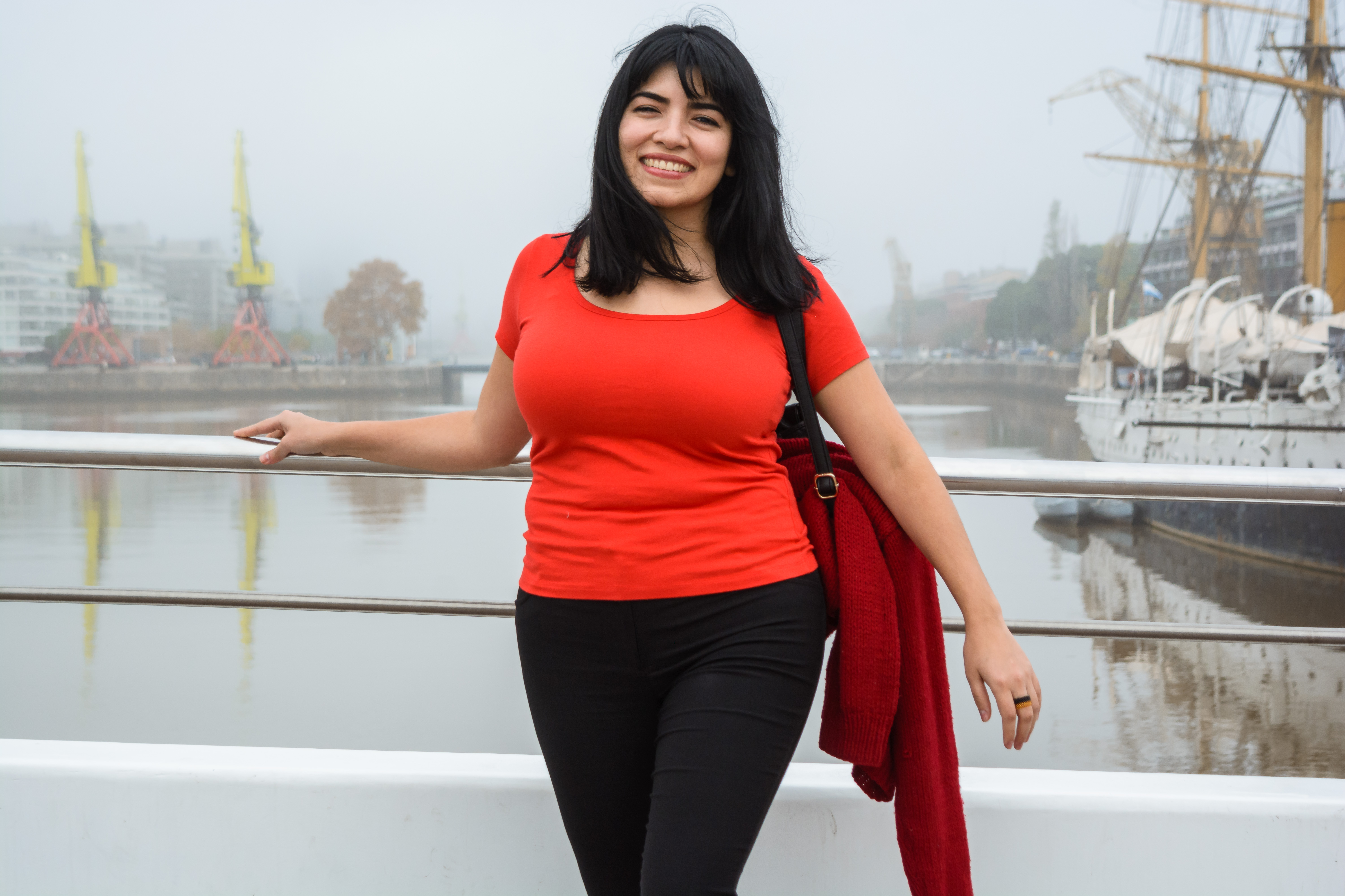 young tourist standing looking at the camera on the Puente De La Mujer on a cloudy day with mist